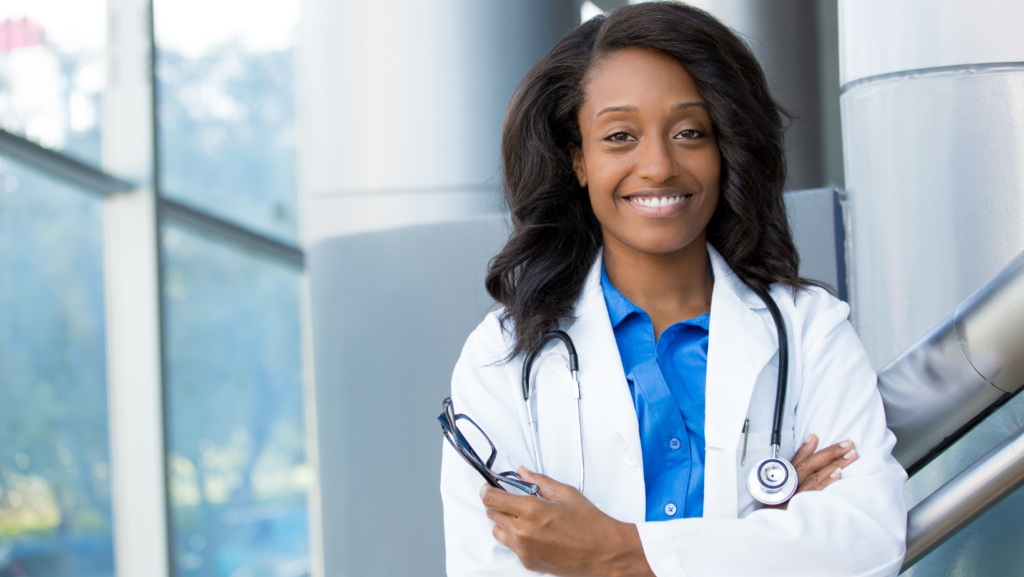 Confident Black woman physician smiling in a white coat with stethoscope